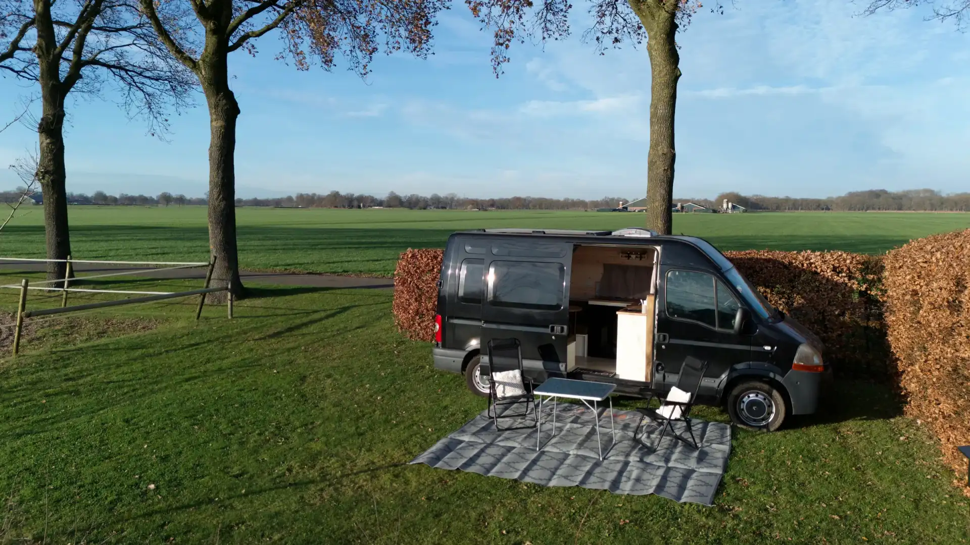 A camper van parked in a serene natural environment at dusk.